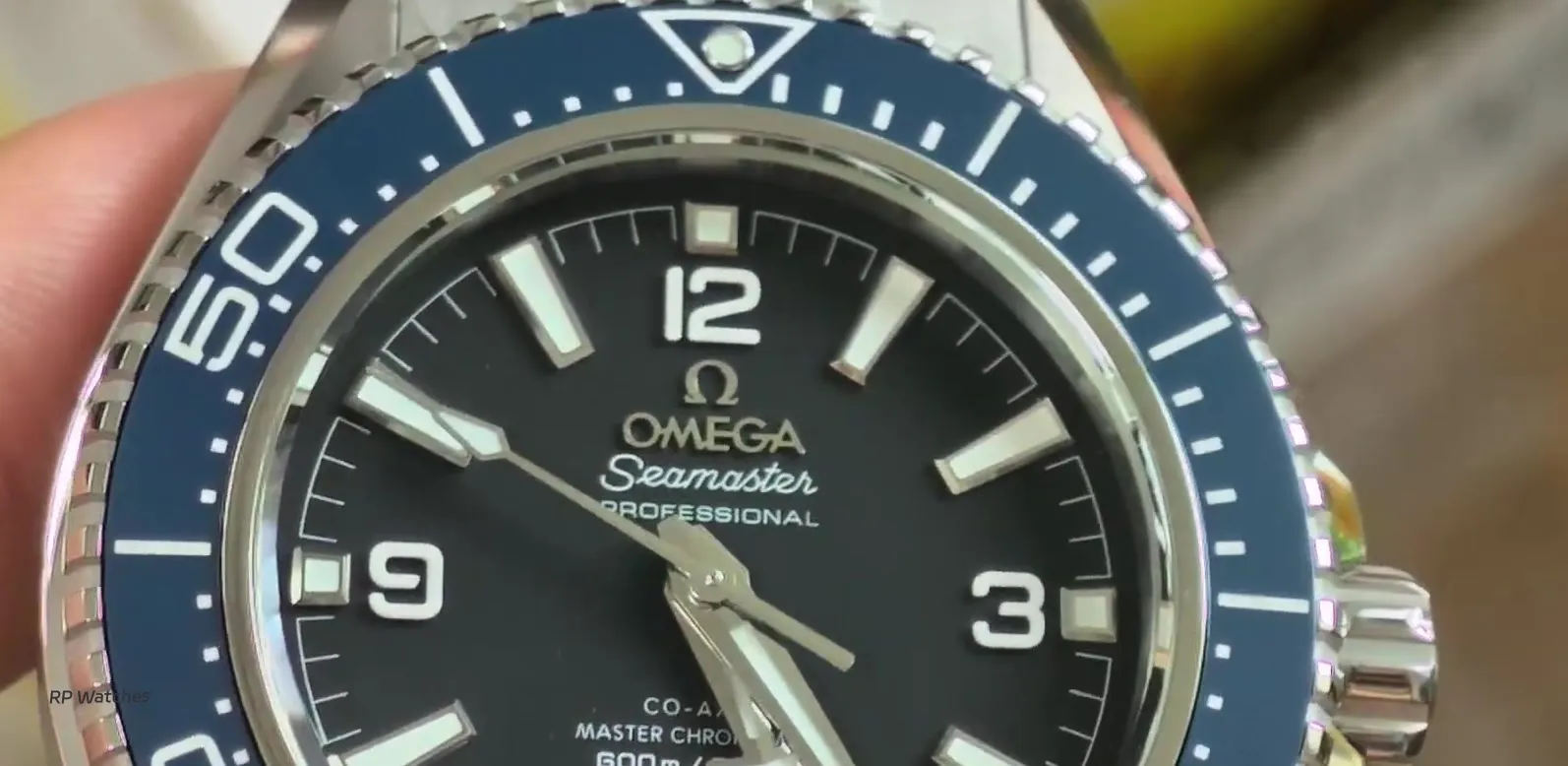 Logo Omega metálico e letras aplicadas no mostrador da réplica VSF Seamaster 600